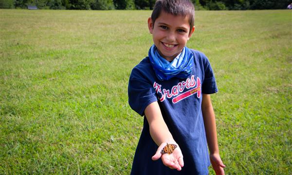 Boy holds out butterfly